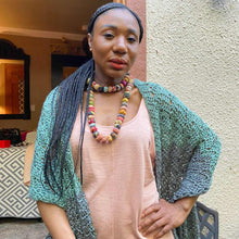 Load image into Gallery viewer, A woman wears a hand-crocheted shawl featuring chevron lace and a row of ruffles down the center back
